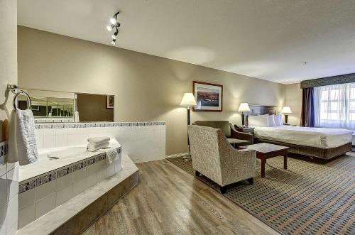 a hotel room with a large white bed at Best Western Plus Osoyoos Hotel & Suites in Osoyoos