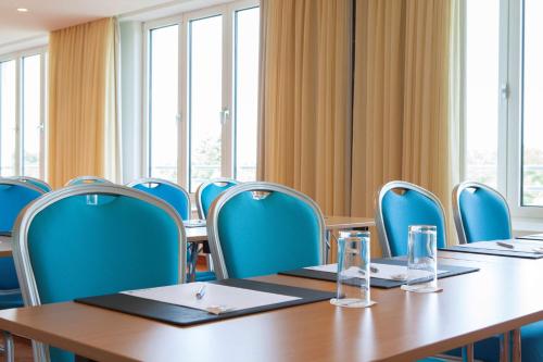 a conference room with tables and chairs and windows at Radisson Blu Hotel Karlsruhe in Ettlingen
