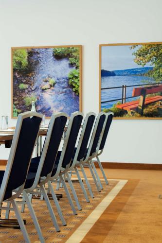 a dining room with a table and a painting at Radisson Blu Hotel Karlsruhe in Ettlingen