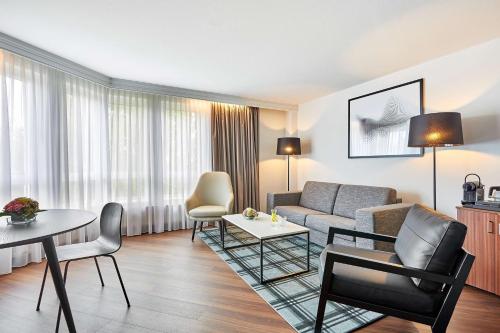 a living room with a couch and a table at Radisson Blu Hotel Karlsruhe in Ettlingen