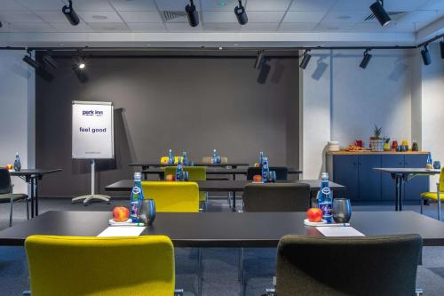 a meeting room with tables and chairs and a screen at Park Inn by Radisson Poznan in Poznań