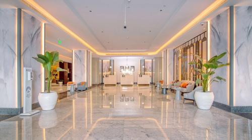 a lobby with potted plants in a building at Radisson Blu Hotel & Resort, Abu Dhabi Corniche in Abu Dhabi