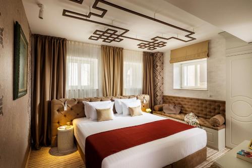 a hotel room with a large bed and a couch at Gallery 37 Powered by ASTON in Plovdiv