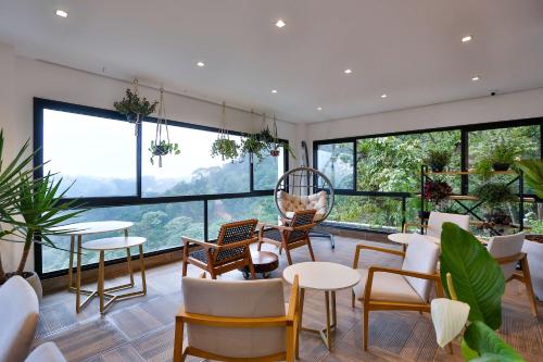 Pokój ze stołami i krzesłami oraz dużymi oknami w obiekcie Carpe Diem Boutique & Spa - BW Premier Collection w mieście Campos do Jordão