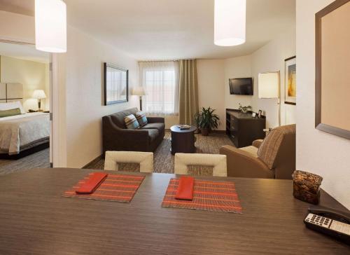 Habitación de hotel con mesa de comedor y sala de estar. en Sonesta Simply Suites Fort Worth en Fort Worth