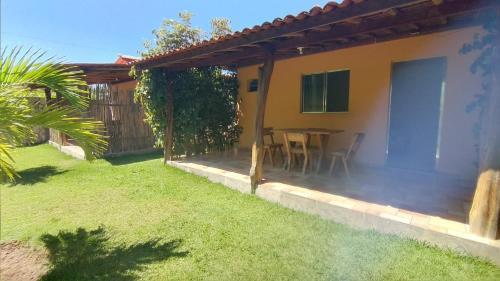 a patio of a house with a table in a yard at Chalés Pirauá in São Miguel dos Milagres