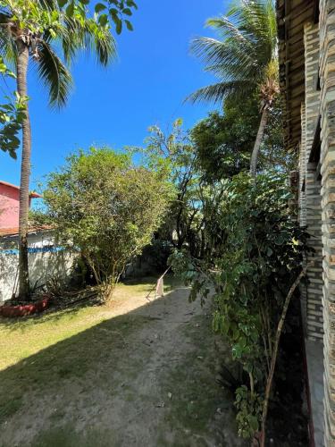 a driveway to a house with palm trees and a giraffe at Hostel do Ceu in Pipa