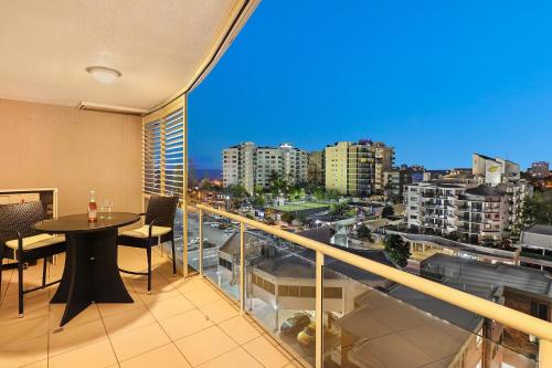 a balcony with a table and a view of a city at Pandanus Mooloolaba in Mooloolaba