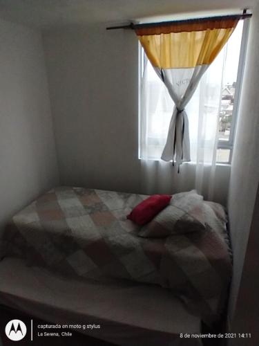 1 cama en un dormitorio con ventana en Oportunidad! Depto en La Serena!, en La Serena