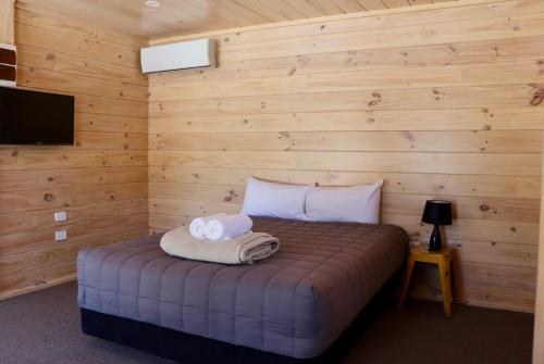 Lakes Edge Lodge في بحيرة تيكابو: غرفة نوم عليها سرير وفوط