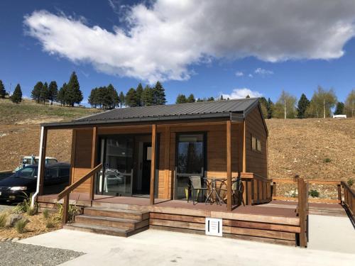 a tiny house with a porch and a deck at Lakes Edge Lodge in Lake Tekapo
