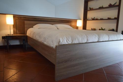 a bedroom with a large bed with a wooden headboard at Villas Catalina in Antigua Guatemala