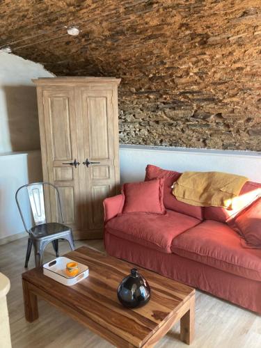 a living room with a red couch and a table at casa dei zitelli studio de charme avec jardin et terrasse in Brando