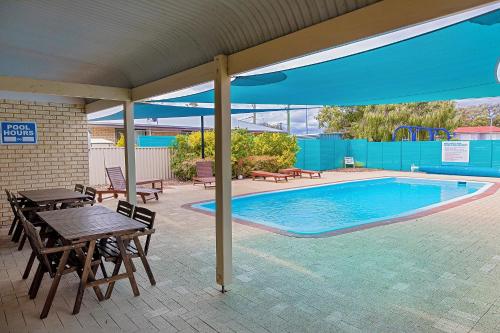 a patio with a table and a swimming pool at Busselton Villas and Glamping Village in Busselton