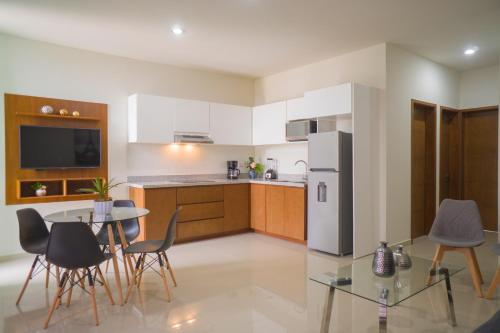 a kitchen with a table and chairs and a refrigerator at Hermoso departamento con alberca, a 10 minutos de la playa!!! in Mazatlán