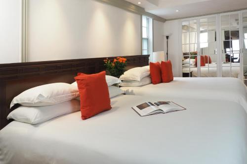 two white beds with red and white pillows at Pasaje de Hamburgo By The Local Way in Mexico City