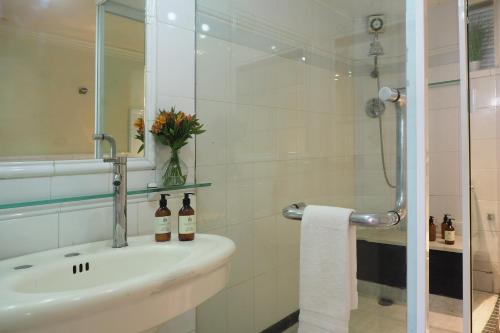 a bathroom with a sink with two bottles on it at Pasaje de Hamburgo By The Local Way in Mexico City