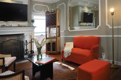 a living room with a red chair and a fireplace at Pasaje de Hamburgo By The Local Way in Mexico City