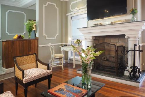 a living room with a fireplace with a vase of flowers at Pasaje de Hamburgo By The Local Way in Mexico City