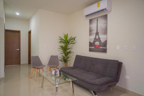 a living room with a couch and a table at Hermoso departamento con alberca, a 10 minutos de la playa!!! in Mazatlán