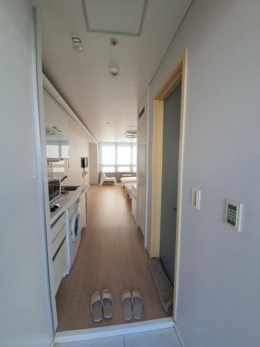 a hallway of a kitchen with two pairs of slippers at Treehouse in Incheon