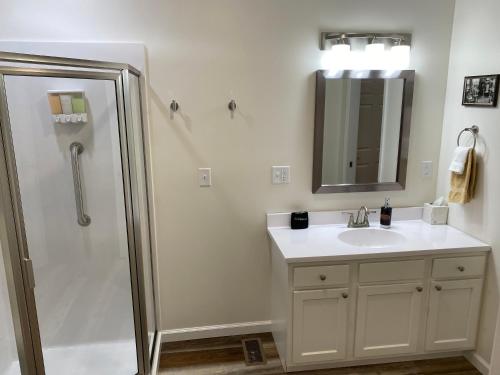 a bathroom with a sink and a shower with a mirror at Hermann Crown Suites in Hermann