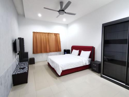a bedroom with a bed and a flat screen tv at SingLeisure Holiday House in Mersing