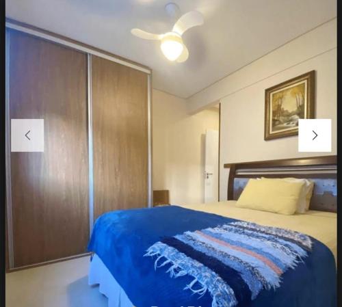 1 dormitorio con 1 cama grande con manta azul en Spazio di Patricia, en Governador Celso Ramos