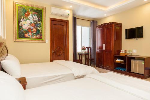 a hotel room with two beds and a television at Sea Memory Hotel in Vung Tau