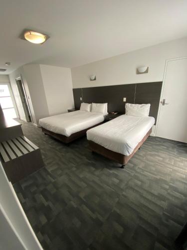 a hotel room with two beds and a window at Brighton Hotel Motel in Pontville