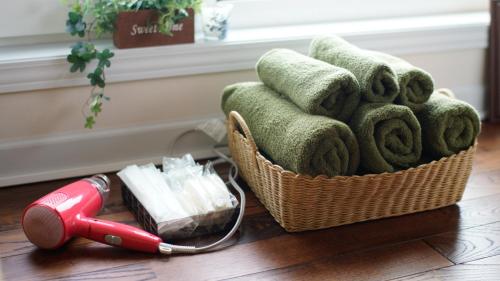 a basket of towels and a red hair dryer on the floor at Joy House in Imari