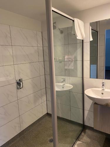 a bathroom with a sink and a shower at Brighton Hotel Motel in Pontville