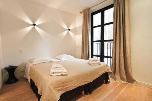 a bedroom with a large bed with towels on it at Appartements Urban et Pure in Cannes