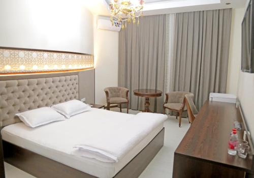 a bedroom with a bed and a table and chairs at Grand Ark Bukhara in Bukhara