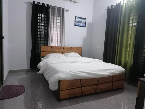 A bed or beds in a room at Wayanad Vista Service Apartment