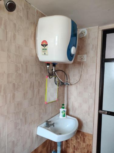 La salle de bains est pourvue d'un réservoir d'eau et d'un lavabo. dans l'établissement 2BHK AC Row House Bunglow in good locality, à Nashik