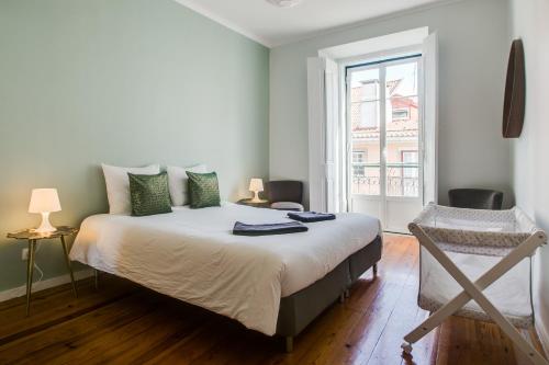 una camera con un grande letto e una finestra di Spacious, Bright and Newly Renovated 2 Bedroom Apartment, Lisbon Historical Center, Madragoa a Lisbona