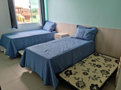a bedroom with two beds and a window at Apartamento Vista Mar – Pé na Areia in Cabo Frio