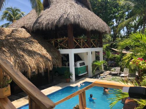 a resort with a swimming pool and a thatch roof at The Beach Break Hotel El Zonte in El Zonte