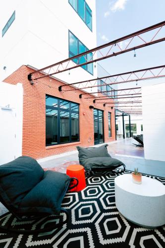 a patio with two chairs and a table and a building at Hotel Dryce in Fort Worth