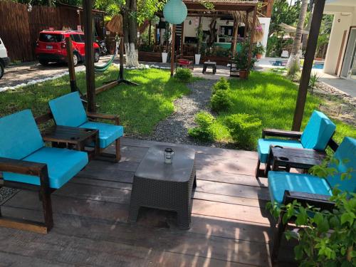 a patio with blue chairs and a table at The Beach Break Hotel El Zonte in El Zonte