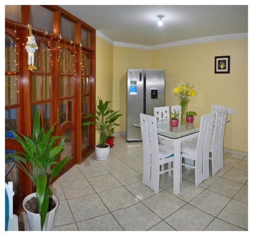 une salle à manger avec une table et des chaises blanches dans l'établissement Hospedaje La Casa Blanca, à Urbanizacion Buenos Aires