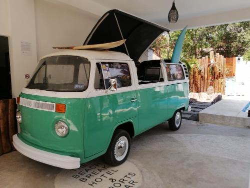 an old green and white van with a surfboard on top at The Beach Break Hotel El Zonte in El Zonte