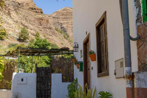 a building with a mountain in the background at La Casa del Orobal in Agaete