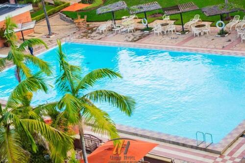 - une vue sur la grande piscine bordée de palmiers dans l'établissement Utalii Hotel, à Nairobi
