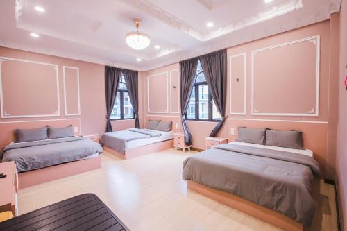 a bedroom with two beds and two windows at Barrington Villa @ Golden Hill in Cameron Highlands