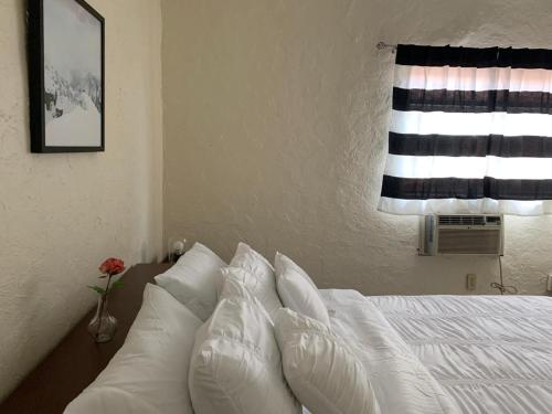 een slaapkamer met een bed met witte kussens en een raam bij Cozy Private Room, near the Airport - Free parking - 01 in Miami