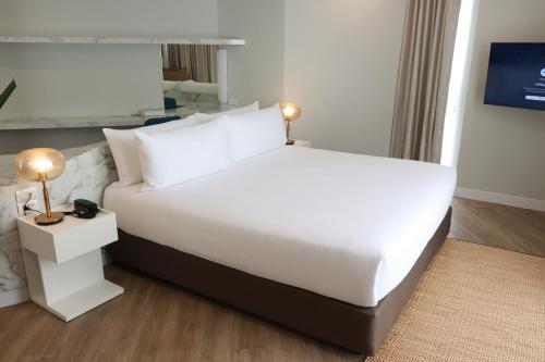 a large white bed in a hotel room at VELA Dhi Udon Thani in Udon Thani