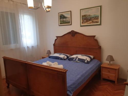sypialnia z drewnianym łóżkiem z 2 poduszkami w obiekcie Villa Tea T w Biogradzie na Moru