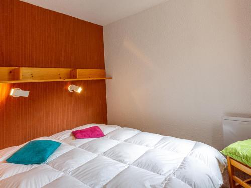 a bedroom with a white bed with two pillows on it at Appartement Valmorel, 2 pièces, 5 personnes - FR-1-356-318 in Valmorel